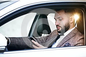 Guy in car with laptop and phone