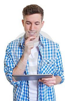 Guy in a checked shirt reading ebook on tablet computer