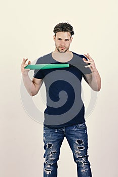 Guy in dark blue tshirt holds bright green bat in hands. Sports and baseball training concept. Player with confident