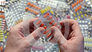 Guy demonstrates the orange pill in her hand top view.