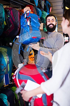 Guy displays a woman a big rucksacks