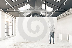 Guy drawing in warehouse interior