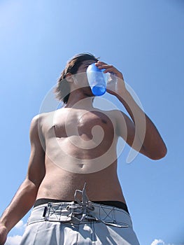 Guy drinking at the beach photo