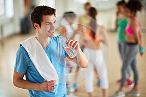 Guy drinking water in gym