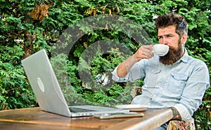 Guy drinks coffee relaxing terrace branches background. Aroma cappuccino. Pleasant moment. Man bearded hipster make