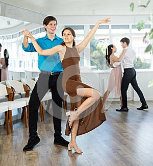 Guy enjoying impassioned merengue with female partner in dance class