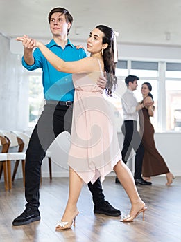 Guy enjoying impassioned merengue with female partner in dance class