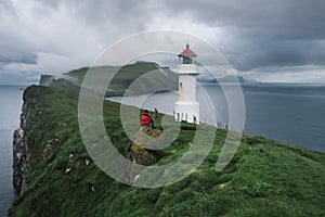 Guy enjoys the view of the lighthouse of Mykines Island, Faroe Islands