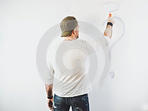 Guy erasing a question mark on a white wall
