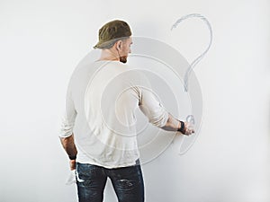 Guy erasing a question mark on a white wall