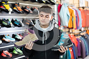 Guy examine view item of autumn comfortable trecking shoes