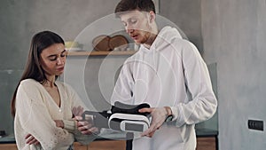 The guy explains to the girl how virtual reality glasses work. Virtual reality teamwork concept