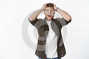 Guy faced failure and dismay, feeling distressed and unlucky, standing drained and upset over gray background with hands
