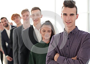 guy with fashionable hairstyle standing in line with casual young people