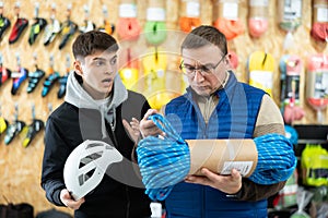 Guy with father chooses rope in store for long hikes