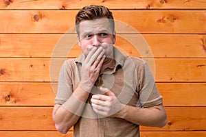 Guy feeling unwell, covering mouth with palm and feeling dizzy