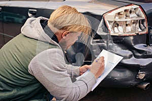 The guy fills out an insurance claim form after the accident