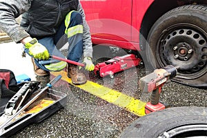 Guy fixing flat tire with tools