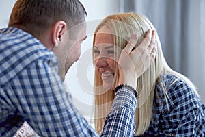 The guy gently stroking the girl`s head, the girl smiles