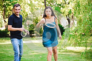 Guy and girl compete in the ring toss