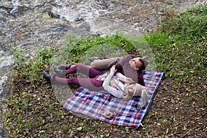 a guy and a girl are drinking tea near the river