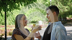 A guy and a girl eat ice cream in a city park