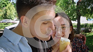 A guy and a girl eat ice cream in a city park
