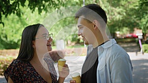 A guy and a girl eat ice cream in a city park