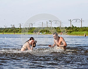 A guy and a girl enjoy splashing around in the Lake