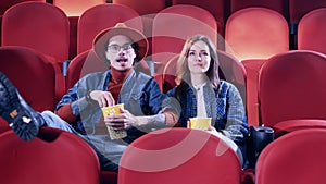 Guy and girl enjoying a film at the cinema. Movie watching, spending time concept.