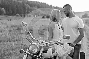 The guy with the girl in a field on a motorcycle