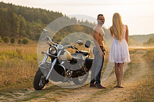 The guy with the girl in a field on a motorcycle