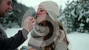 Guy and girl in the forest, drinking tea in winter