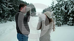 Guy and girl in the forest, drinking tea in winter