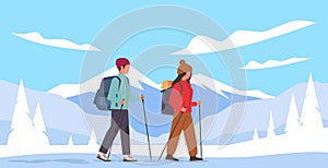 Guy and girl go with their gear into mountains in winter. Man and woman hiking with backpack and stick in snowy forest