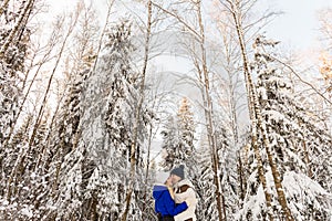 The guy and the girl have a rest in the winter woods.