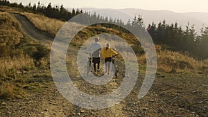 Guy and girl having walk with bicycles. Bicyclists looking around landscape