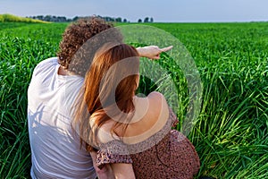 A guy and a girl are hugging on a green field