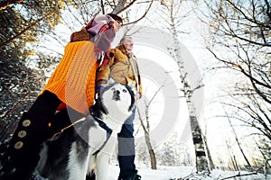 Guy and girl with husky dog in winter in the forest, bottom view