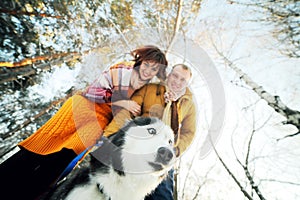 Guy and girl with husky dog in winter in the forest, bottom view