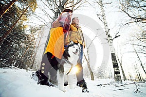 Guy and girl with husky dog in winter in the forest, bottom view