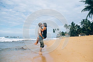 A guy and a girl are kissing on a beach