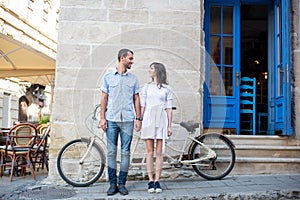 Guy and girl near tandem bike, walls and vintage door