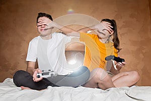 A guy with a girl playing a video game using cheating