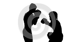 Guy with a girl preparing for a kickboxing competition. Silhouette. White background