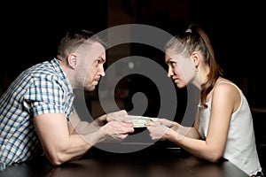 The guy and the girl are pulling each other`s common small cash savings