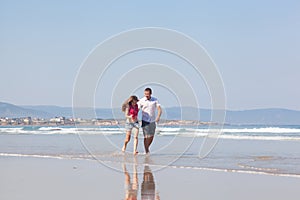 Guy and the girl run on a beach