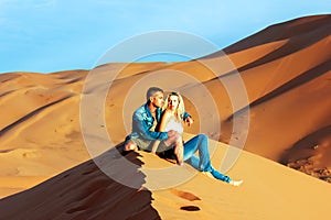 Guy and girl on the sand dunes in the Sahara Desert
