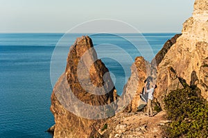 Guy and girl at the sea hugging on the edge of the cliff