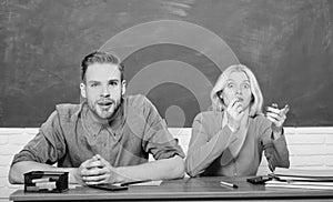 Guy and girl sit at desk in classroom. Wondering about result. Studying in college or university. Couple friends